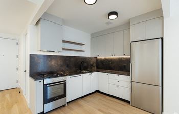 a kitchen with white cabinets and a stainless steel refrigerator